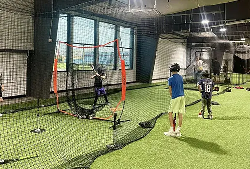 Young athletes practicing in batting cages