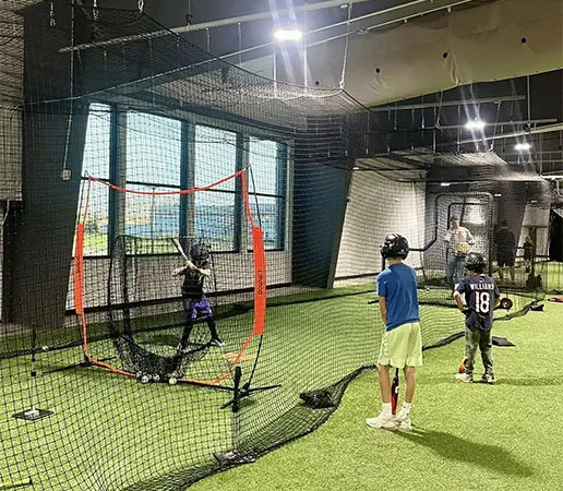 Young athletes practicing in batting cages