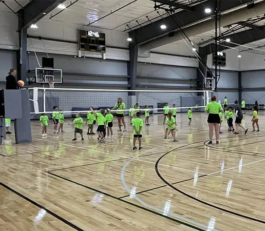 Young athletes playing volleyball on court